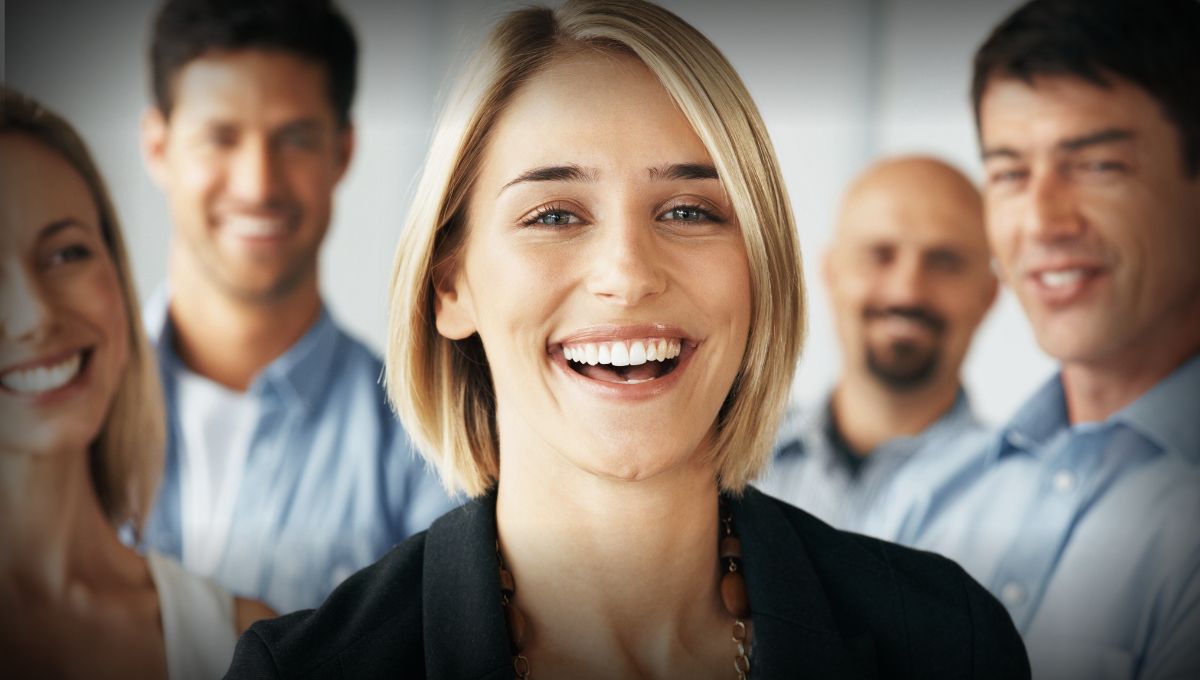 blonde haired woman looking at the camera and laughing in the office